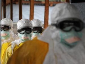 Funcionários da área da saúde usam roupas de proteção contra o ebola em hospital