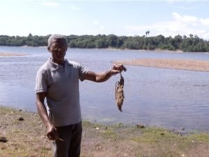 Pescador mostra carcaça de peixe (Foto: TV Anhanguera)