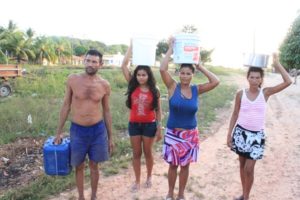 Comunidade carregando lata dágua