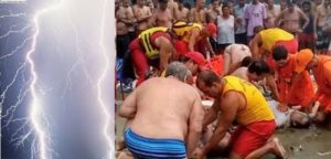 Salva-vidas tentam reanimar banhistas após raio atingir a praia do Canto do Forte, em Praia Grande (SP)